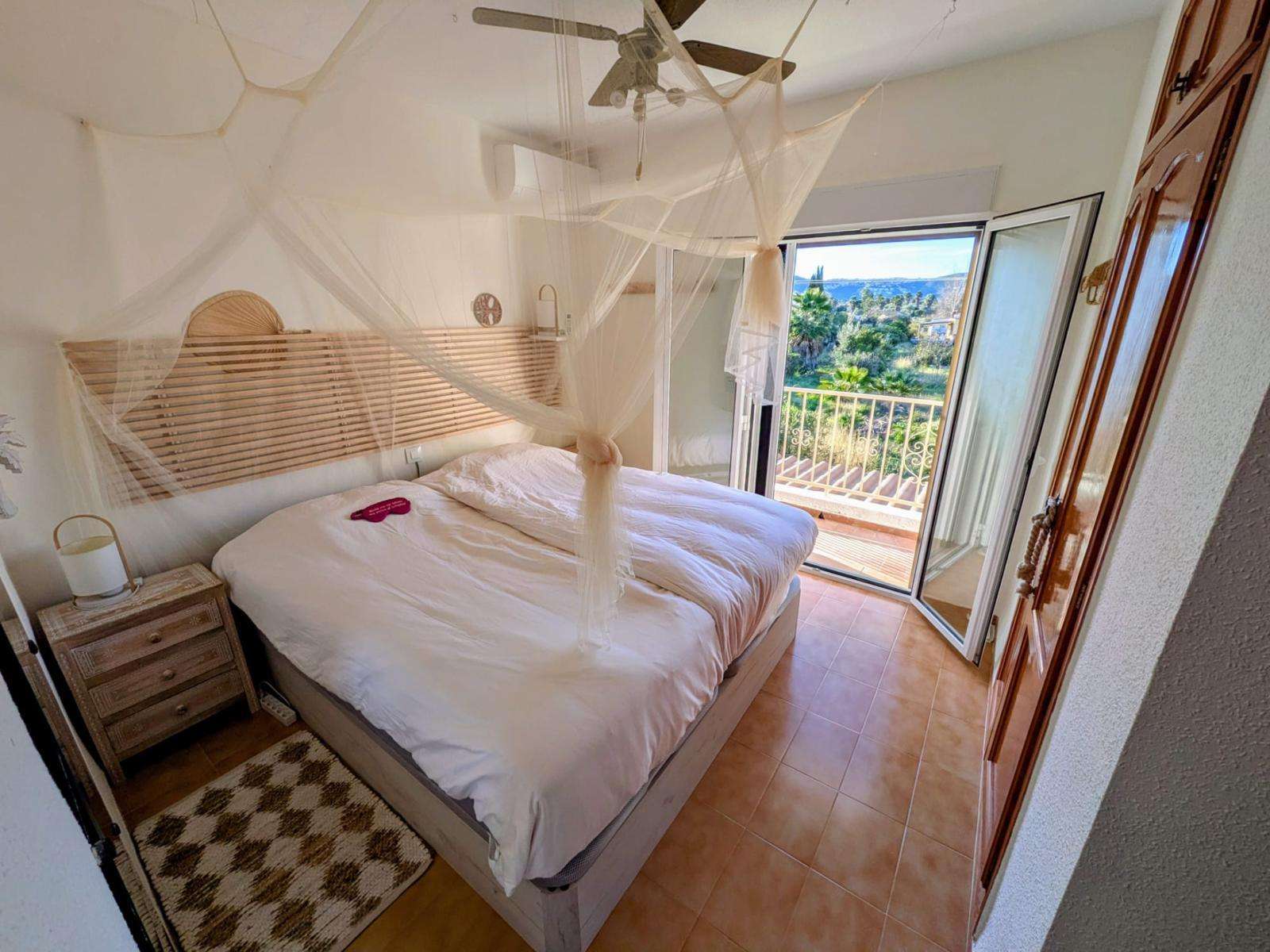 Main bedroom with mosquito net and balcony