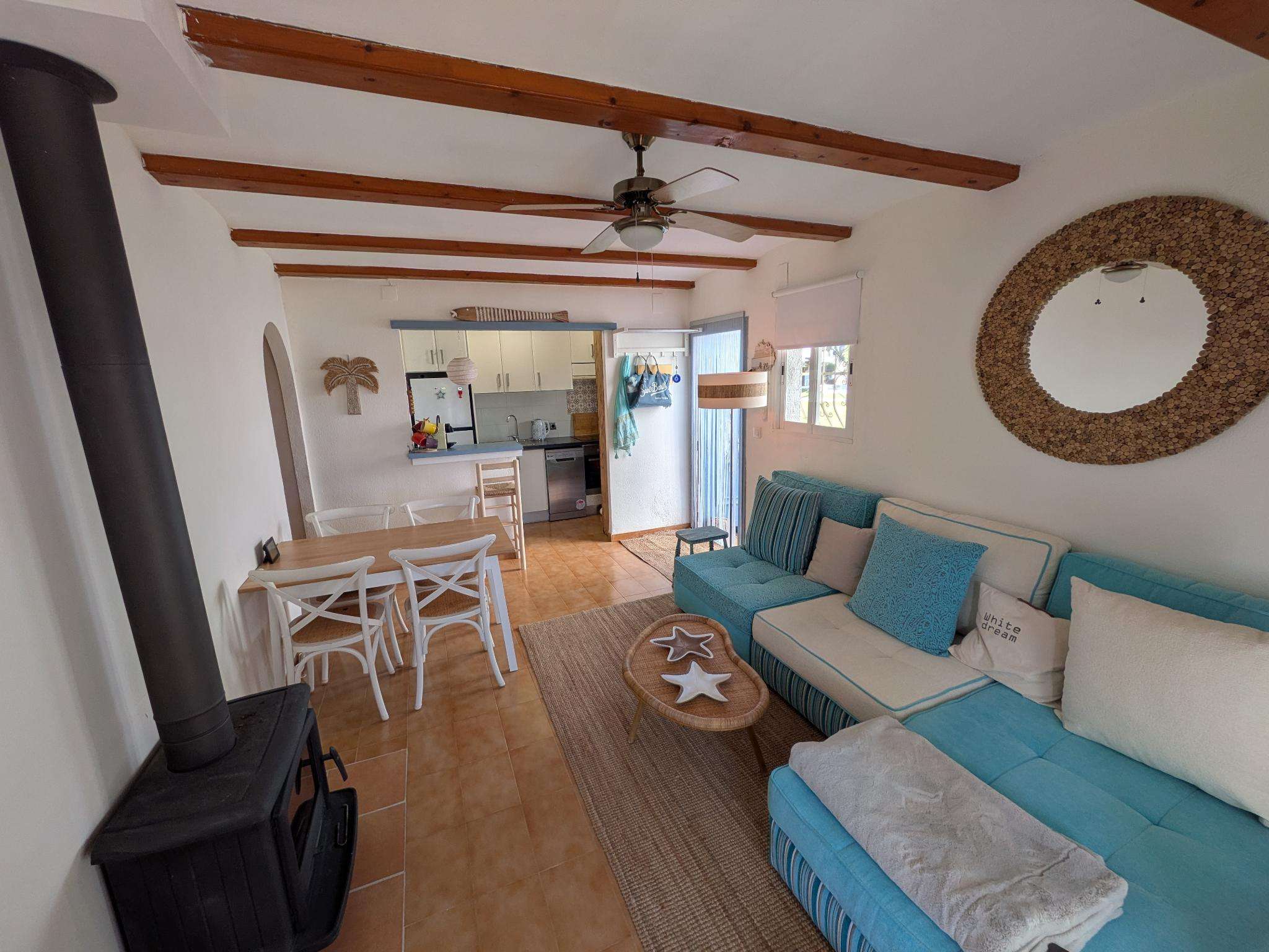 Living room with sea-blue sofa, dining area and open kitchen
